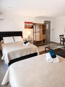 a bedroom with two beds with towels on them at Hôtel Restaurant le Mistral in Peipin +42 photos