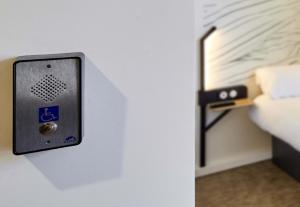 a switch on a wall next to a bed at B&B HOTEL Magnanville in Magnanville