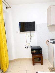 a room with a television on a wall with a table at Phonex haven near Westside Mall in Nakuru