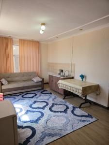 a living room with a couch and a rug at Гостевой дом "Greenway Tourist" in Bosteri