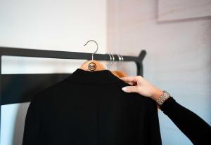 a person holding a black shirt on a hanger at B&B HOTEL Magnanville in Magnanville +6 photos