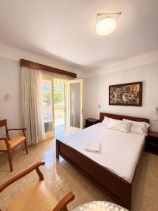 a bedroom with a bed and a chair and a window at Amphitrite's Paradise Apartments in Olympic Beach