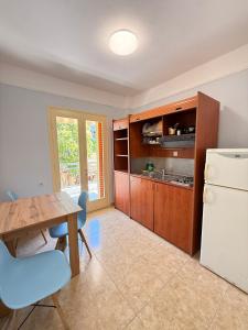 a kitchen with a table and a refrigerator at Amphitrite's Paradise Apartments in Olympic Beach