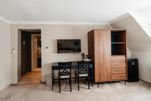 a dining room with a table and a cabinet at Hotel Cocó in Timişoara