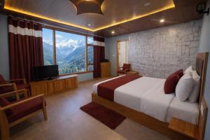 a bedroom with a bed and a television and mountains at The Sana Cottge, Manali - Affordable Luxury Stay in Manali in Manāli