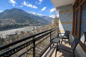 a balcony with two chairs and a view of the mountains at The Sana Cottge, Manali - Affordable Luxury Stay in Manali in Manāli +12 photos