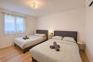 a bedroom with two beds and a window at L'Esterel Appartements Plage 450m & Gare Saint-Raphael 950m in Fréjus