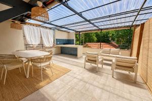 a conservatory with a table and chairs and a glass ceiling at L'Esterel Appartements Plage 450m & Gare Saint-Raphael 950m in Fréjus