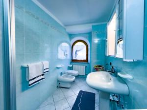 a blue bathroom with a sink and a toilet at Casa Bamby in Cogolo +140 photos