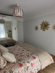 a bedroom with a bed with a floral bedspread at Le repos de Cézanne in Salon-de-Provence