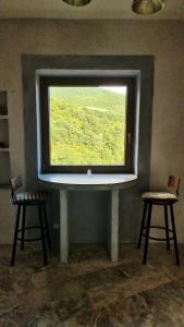 a window in a room with two chairs in front of it at La Roccia Rossa in Stribugliano