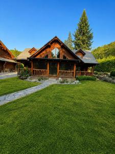 a large log cabin with a lawn in front of it at Chalet Velora in Oščadnica