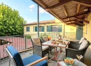 eine Terrasse mit Tisch und Stühlen auf einem Balkon in der Unterkunft GRAN DELTA River & Nature Hotel in Rosolina