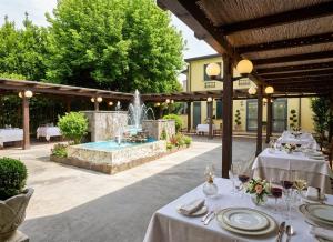 ein Restaurant mit einem Brunnen inmitten einer Terrasse in der Unterkunft GRAN DELTA River & Nature Hotel in Rosolina
