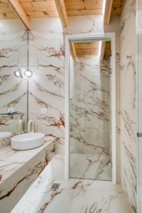 a marble bathroom with a sink and a shower at Nalia Suites in Nafplio +70 photos