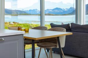 a kitchen and living room with a table and a couch at Steigen Lodge Sjøhytter in Engeløya