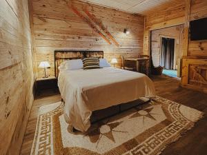 a bedroom with a bed in a log cabin at La Posada Cercedilla in Cercedilla