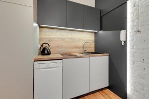 a kitchen with white cabinets and a sink at G-8HOSTEL Gdynia in Gdynia +43 photos