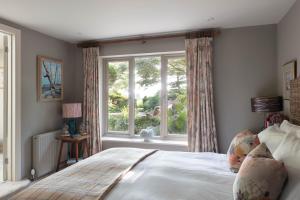a bedroom with a bed and a large window at Nest Lodge by The Butler Collection in Pulborough