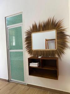 a mirror on a wall next to a door at Ebruli Guest House in Nungwi
