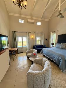 a bedroom with a bed and two chairs at Grand View Cottages - 2 King Suites - Entire Cottage in Riebeek-Kasteel