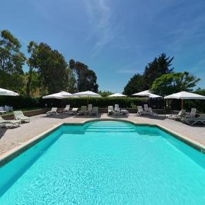 a swimming pool with chairs and umbrellas at Agriturismo Le Pescine in Vada