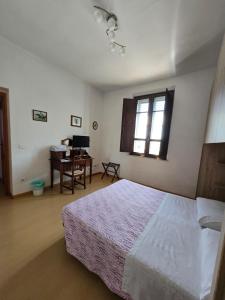 a bedroom with a bed and a desk and a window at Alfredo II Affittacamere in Siena