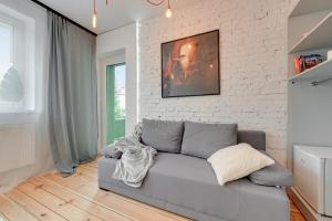 a living room with a couch and a brick wall at G-8HOSTEL Gdynia in Gdynia