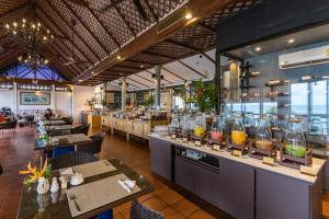 a restaurant with tables and chairs and a bar at Centara Villas Phuket in Karon Beach