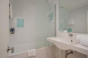 a white bathroom with a sink and a shower at Hotel Eden Park by Brava Hoteles in Riudellots de la Selva