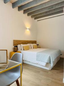 a bedroom with a white bed and a desk at Alegoría Coliving Experience in Seville