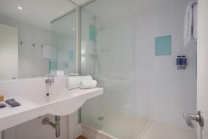 a white bathroom with a sink and a shower at Hotel Eden Park by Brava Hoteles in Riudellots de la Selva