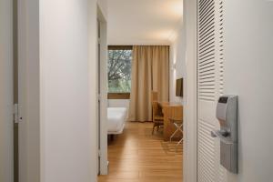 a corridor of a hotel room with a bedroom at Hotel Eden Park by Brava Hoteles in Riudellots de la Selva