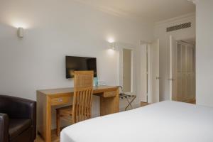 a bedroom with a desk and a bed and a computer at Hotel Eden Park by Brava Hoteles in Riudellots de la Selva +35 photos