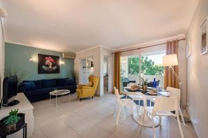 a living room with a blue couch and a table at Apartamento Alquimia by Algarve Holidays in Vale do Lobo
