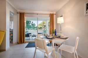 a dining room with a table and chairs and a view of the water at Apartamento Alquimia by Algarve Holidays in Vale do Lobo