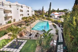 an overhead view of a swimming pool with palm trees and buildings at Apartamento Alquimia by Algarve Holidays in Vale do Lobo