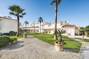 a courtyard with palm trees and a building at Apartamento Alquimia by Algarve Holidays in Vale do Lobo