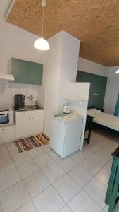a kitchen with white cabinets and a table in it at Ferouli Residence in Rizá