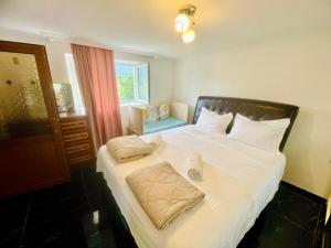 a bedroom with a large bed with white sheets and pillows at House of Warmth in Bagdatʼi