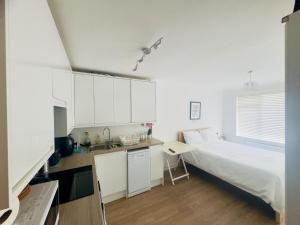 a small bedroom with a bed and a sink at Studio - Sleeps 2 - Wifi - Parking in Dunstable