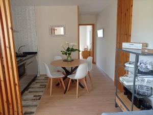 a dining room with a table and white chairs at Casa Da Ponte in Lobios