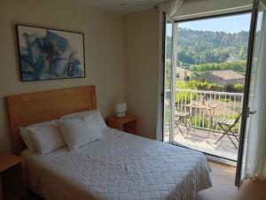 a bedroom with a bed and a sliding glass door at Casa Da Ponte in Lobios