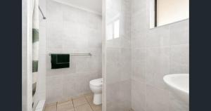 a white bathroom with a toilet and a sink at A&A Lodge Motel in Emerald