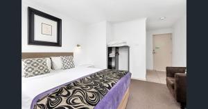 a hotel room with a bed and a chair at A&A Lodge Motel in Emerald