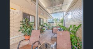 an outdoor patio with chairs and tables and plants at A&A Lodge Motel in Emerald +7 photos