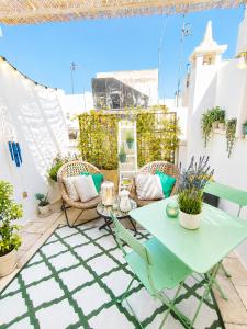 a patio with a green table and chairs at TorreParadiso Holidays in Polignano a Mare