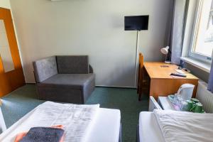 a hotel room with a chair and a desk at Pension Silma in Rychwald