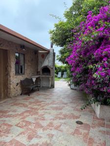a patio with a stone fireplace and purple flowers at Casa de Joaquina in O Grove