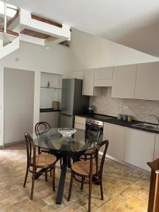 a kitchen with a glass table and chairs in it at Dimora Lieta in Pisticci